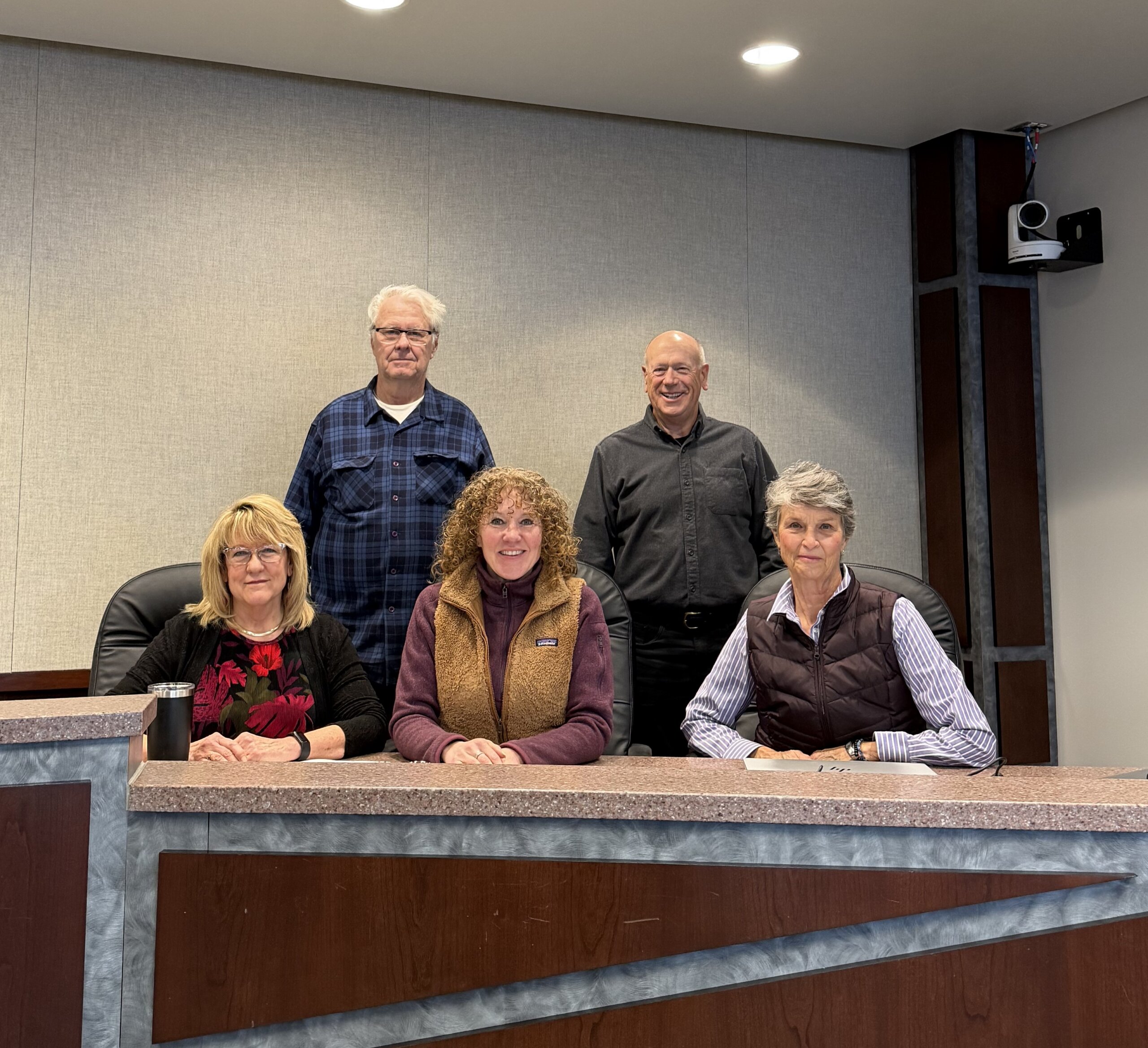 The RCWD board of Managers sitting at their meeting podium. two managers standing in the back row, Manager John Waller and Manager Michael Bradley, with three managers sitting in front row, from left to right, Manager Hegland, Manager Roberston, and Manager Weinandt.